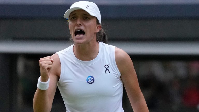 Poland's Iga Swiatek celebrates after beating Switzerland's Belinda Bencic in a women's singles match on day seven of the Wimbledon tennis championships in London, Sunday, July 9, 2023. (Kirsty Wigglesworth/AP)