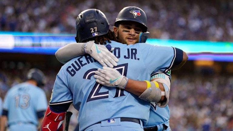 Toronto Blue Jays' Bo Bichette, right, is hugged by Vladimir Guerrero Jr. after Bichette's two-run home run against the Los Angeles Dodgers during the third inning of a baseball game Tuesday, July 25, 2023, in Los Angeles. (Marcio Jose Sanchez/AP)