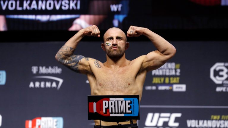 Alexander Volkanovski poses on the scale during a ceremonial weigh-in for the UFC 290 mixed martial arts event, Friday, July 7, 2023, in Las Vegas. Volkanovski is scheduled to face Yair Rodriguez on Saturday in a featherweight bout. (Steve Marcus/Las Vegas Sun via AP)