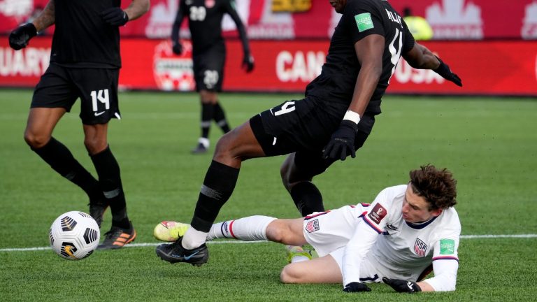 United States' Brendan Aaronson (11) picks up a foul for a tackle on Canada's Kamal Miller (4) during first half World Cup qualifying soccer action in Hamilton, Ont., Sunday, Jan. 30, 2022. (Frank Gunn/CP)