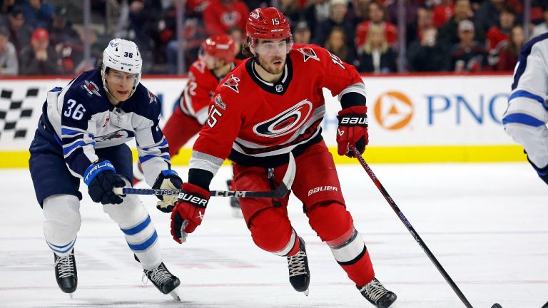 Carolina Hurricanes' Dylan Coghlan (15) carries the puck in front of Winnipeg Jets' Morgan Barron (36) during the second period of an NHL hockey game in Raleigh, N.C., Tuesday, March 14, 2023. (Karl B DeBlaker/AP Photo)