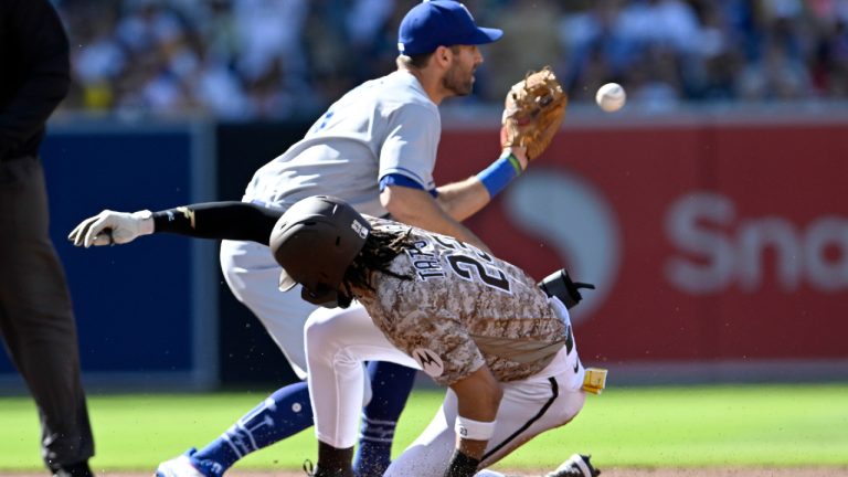 San Diego Padres' Fernando Tatis Jr., bottom, safely slides into second base for a double as Los Angeles Dodgers shortstop Chris Taylor, top, takes a late throw during the first inning of a baseball game in San Diego, Sunday, May 7, 2023. (Alex Gallardo/AP)