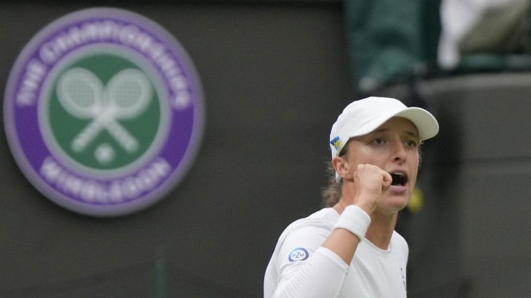 Poland's Iga Swiatek celebrates defeating China's Zhu Lin in the first round women's singles match on day one of the Wimbledon tennis championships in London. (Alastair Grant/AP)