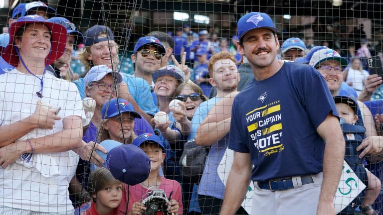 Toronto Blue Jays pitcher Jordan Romano poses for a photo with fans before the team's baseball game against the Seattle Mariners, Thursday, July 7, 2022, in Seattle. (Ted S. Warren/AP Photo)