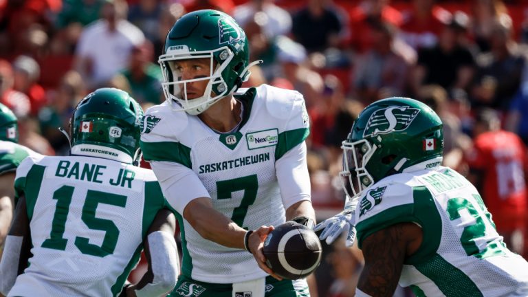 Saskatchewan Roughriders quarterback Trevor Harris, centre, hands the ball off to running back Jamal Morrow during first half CFL football action against the Calgary Stampeders in Calgary, Alta., Saturday, June 24, 2023. (Jeff McIntosh/CP)