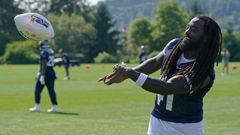 Alex Collins tosses an autographed football to fans after NFL football practice, Thursday, Aug. 19, 2021, in Renton, Wash. (Ted S. Warren/AP)