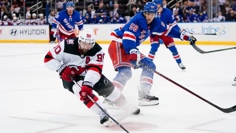 New Jersey Devils' Tomas Tatar (90) vies for control of the puck against New York Rangers' Brandon Scanlin (58) during the third period of an NHL preseason hockey game Thursday, Sept. 29, 2022, in New York. The Devils won 5-2. (Frank Franklin II/AP) 