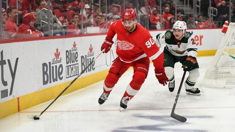 Detroit Red Wings' Joe Veleno, left, skates with the puck in front of Minnesota Wild's Calen Addison during the second period of an NHL hockey game, Saturday, Oct. 29, 2022, in Detroit. (Jose Juarez/AP)