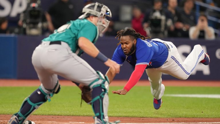 Toronto Blue Jays' Vladimir Guerrero Jr.  slides safely home in front of Seattle Mariners catcher Cal Raleigh on an RBI double off the bat of Matt Chapman during third inning American League MLB baseball action in Toronto on Friday, April 28, 2023. (Chris Young/CP)