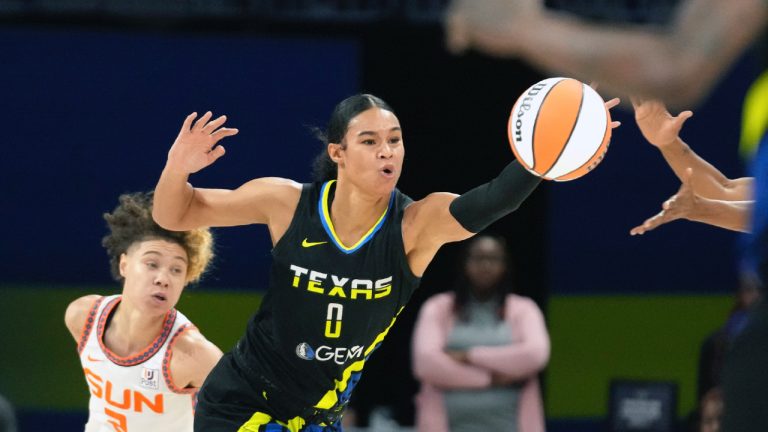 Dallas Wings forward Satou Sabally (0) reaches for the ball in front of Connecticut Sun guard Natisha Hiedeman (2) during the first half of a WNBA basketball basketball game in Arlington, Texas, Saturday, Aug. 12, 2023. (LM Otero/AP)