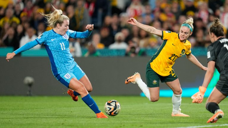 England's Lauren Hemp, left, scores her side's second goal past Australia's goalkeeper Mackenzie Arnold, as Australia's Ellie Carpenter, centre, tries to block during the Women's World Cup semifinal soccer match between Australia and England at Stadium Australia in Sydney, Australia, Wednesday, Aug. 16, 2023. (Abbie Parr/AP)