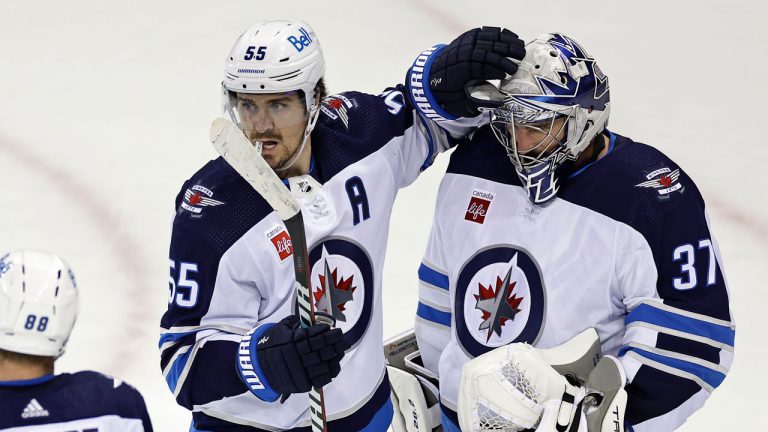 Winnipeg Jets center Mark Scheifele (55) celebrates with goaltender Connor Hellebuyck after the third period of an NHL hockey game against the New York Rangers. (Adam Hunger/AP)