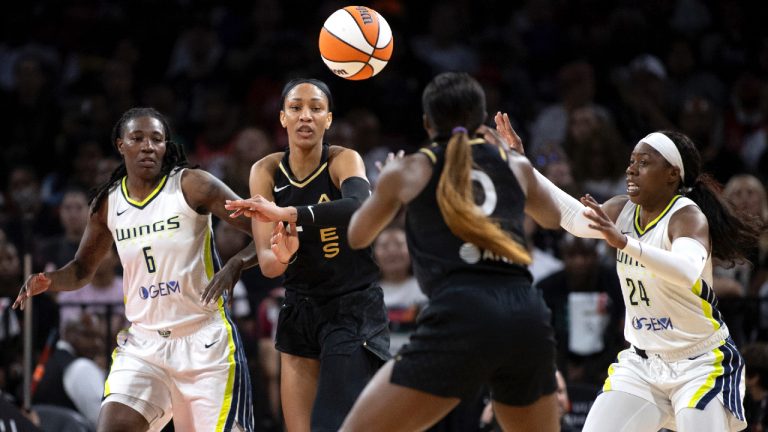 Las Vegas Aces forward A'ja Wilson, centre left, passes to guard Jackie Young while Dallas Wings forward Natasha Howard (6) and guard Arike Ogunbowale (24) defend during the first half in Game 1 of a WNBA basketball semifinal series, Sunday, Sept. 24, 2023, in Las Vegas. (Ellen Schmidt/Las Vegas Review-Journal via AP)