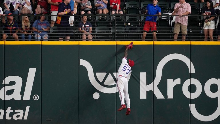 Fans, top, look on as Texas Rangers right fielder Adolis Garcia (53) makes a leaping attempt to reach a solo home run ball hit by Houston Astros' Mauricio Dubon in the ninth inning of a baseball game, Monday, Sept. 4, 2023, in Arlington, Texas. (Tony Gutierrez/AP)