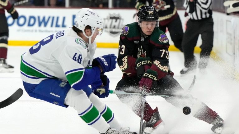 Vancouver Canucks defenseman Cole McWard and Arizona Coyotes right wing Jan Jenik (73) race for the puck during the first period of an NHL hockey game Thursday, April 13, 2023, in Tempe, Ariz. (Rick Scuteri/AP)