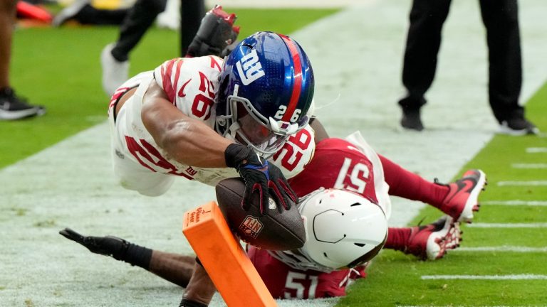 New York Giants running back Saquon Barkley (26) dives into the end zone for a touchdown as Arizona Cardinals linebacker Krys Barnes (51) defends during the second half of an NFL football game. (Rick Scuteri/AP)