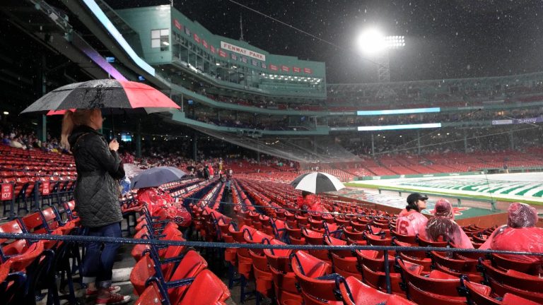 Baseball fans use umbrellas while seated in the stands during a rain delay before a scheduled baseball game between the New York Yankees and the Boston Red Sox, Wednesday, Sept. 13, 2023, in Boston. (Steven Senne/AP)