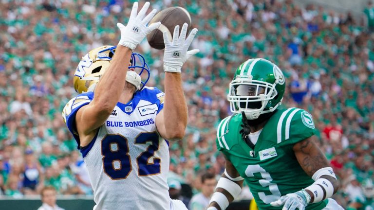 Winnipeg Blue Bombers receiver Drew Wolitarsky (82) catches for a touchdown as Saskatchewan Roughriders defensive back Nic Marshall (3) looks on during the first half of CFL Labour Day Classic football action in Regina, Sunday, Sept. 3, 2023. (Heywood Yu/CP)