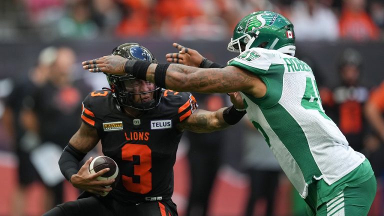 B.C. Lions quarterback Vernon Adams Jr., left, is sacked by Saskatchewan Roughriders' Pete Robertson during the first half of a CFL football game, in Vancouver, on Saturday, July 22, 2023. Adams Jr. left the game with an injury on the play. (Darryl Dyck/THE CANADIAN PRESS)