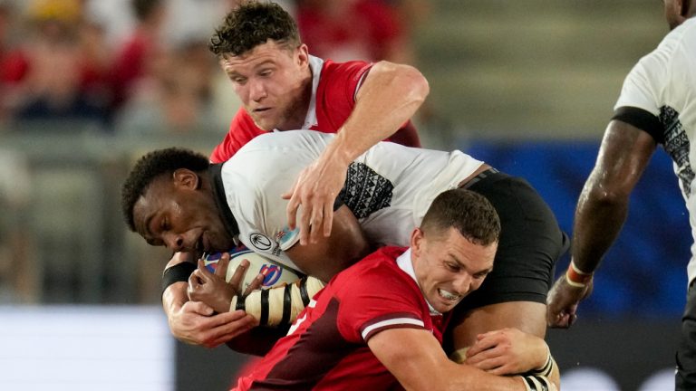 Fiji's Viliame Mata, centre, is tackled by Wales' George North, below, during the Rugby World Cup Pool C match between Wales and Fiji at the Stade de Bordeaux in Bordeaux, France, Sunday, Sept. 10, 2023. (Themba Hadebe/AP) 