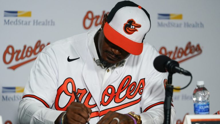 Former Baltimore Orioles player Adam Jones signs a contract to officially retire prior to a baseball game between the Orioles and the Tampa Bay Rays, Friday, Sept. 15, 2023, in Baltimore. (Julio Cortez/AP)