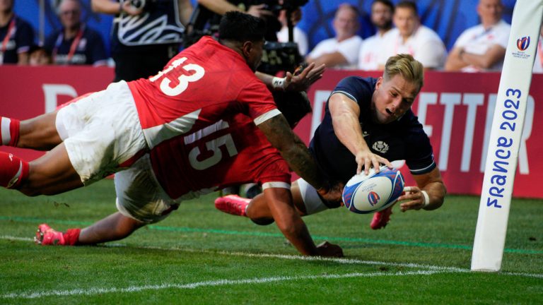 Scotland's Duhan van der Merwe, right, Tonga's Malakai Fekitoa, left, and Salesi Piutau fight for the ball during the Rugby World Cup Pool B match between Scotland and Tonga at the Stade de Nice, in Nice, France, Sunday, Sept. 24, 2023. (Daniel Cole/AP) 