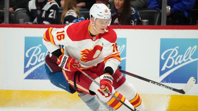 Calgary Flames defenceman Nikita Zadorov, front, collects the puck as Colorado Avalanche right wing Logan O'Connor defends in the third period of an NHL hockey game Sunday, March 13, 2022, in Denver. (David Zalubowski/AP)