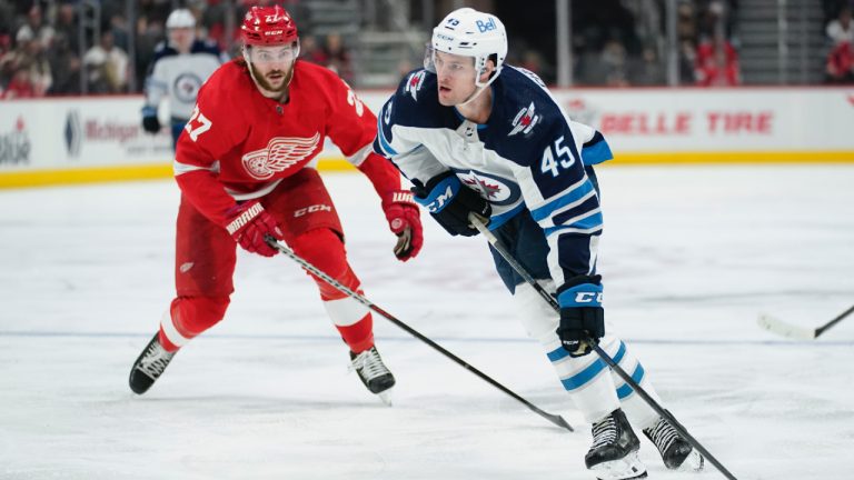 Winnipeg Jets defenceman Declan Chisholm (45) looks to shoot as Detroit Red Wings center Michael Rasmussen (27) looks on in the third period of an NHL hockey game Thursday, Jan. 13, 2022, in Detroit. (Paul Sancya/AP)