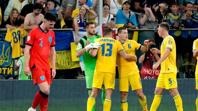 England's Declan Rice walks on the pitch as Ukraine's players celebrate after the Euro 2024 group C qualifying soccer match between Ukraine and England in Wroclaw, Poland, Saturday, Sept. 9, 2023. (Czarek Sokolowski/AP Photo)