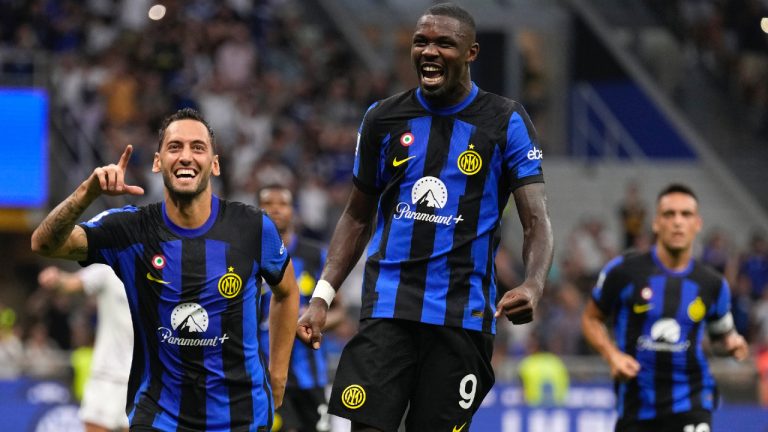 Inter Milan's Hakan Calhanoglu, left, celebrates with Inter Milan's Marcus Thuram after scoring his sides third goal during the Serie A soccer match between Inter Milan and Fiorentina at the San Siro Stadium, in Milan, Italy, Sunday, Sept. 3, 2023. (Antonio Calanni/AP)