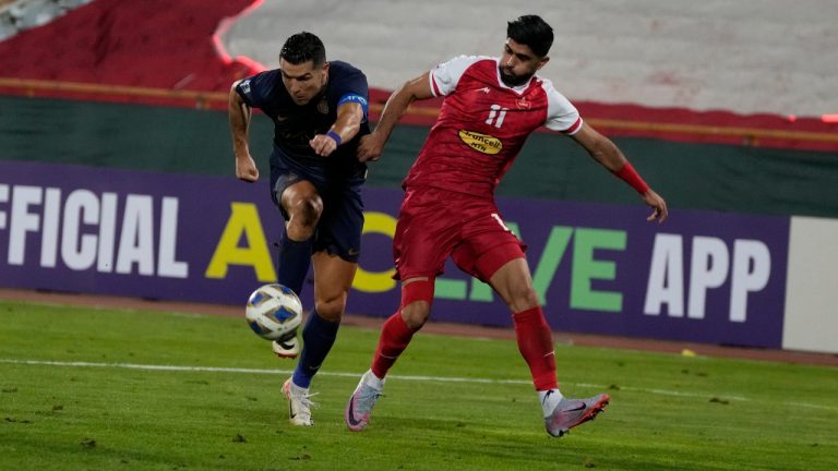 Al Nassr's Cristiano Ronaldo, left, vies for the ball with Iran's Persepolis Danial Esmaeilifar during their AFC Champions League soccer match at the Azadi Stadium in Tehran, Iran, Tuesday, Sept. 19, 2023. (Vahid Salemi/AP)