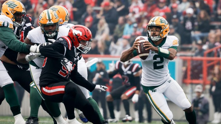 Edmonton Elks quarterback Tre Ford, right, scrambles away from Calgary Stampeders defensvie lineman Julian Howsare during first half CFL football action in Calgary, Alta., Monday, Sept. 4, 2023. (Jeff McIntosh/AP)