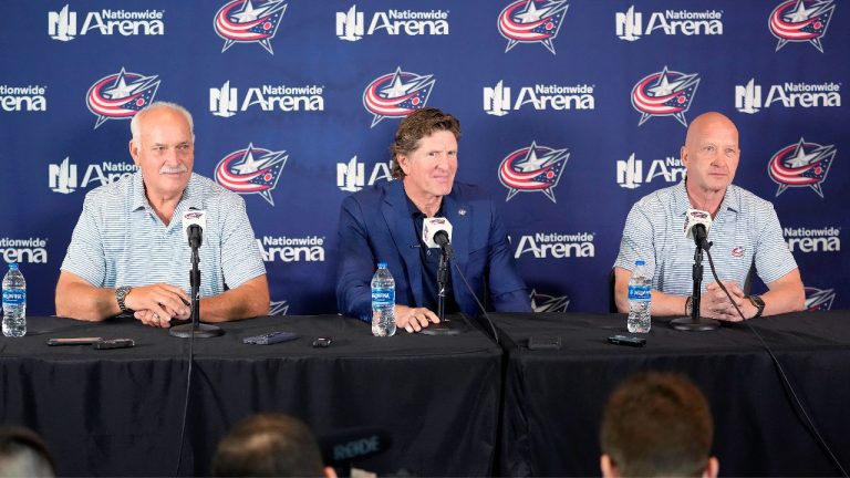 Mike Babcock sits between Columbus Blue Jackets president John Davidson, left, and GM Jarmo Kekalainen as they address the media as when  introduced Babcock as their new head coach during a news conference on Saturday, July 1, 2023 in Columbus, Ohio. (Kyle Robertson/The Columbus Dispatch via AP)