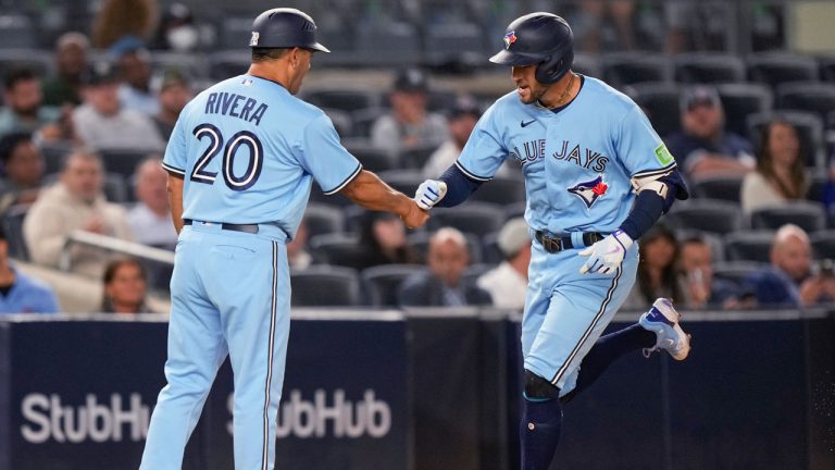 Toronto Blue Jays George Springer (4) celebrates with third base coach Luis Rivera (20) after hitting a homerun during the first inning a baseball game against the New York Yankees. (Bryan Woolston/AP)