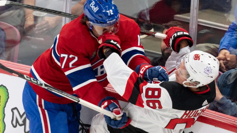 Montreal Canadiens Arber Xhekaj (72) checks New Jersey Devils Jack Hughes (86) into the boards during first period NHL preseason hockey action in Montreal on Monday, Sept. 25, 2023. (Christinne Muschi/CP)