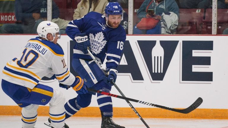 Toronto Maple Leafs' Noah Gregor is checked by Buffalo Sabres' Henri Jokiharju during the third period of the Kraft Hockeyville pre-season game between the Sabres and the Leafs at the Joe Thornton Community Centre in St. Thomas, Ont., Wednesday, Sept. 27, 2023. (Geoff Robins/CP)