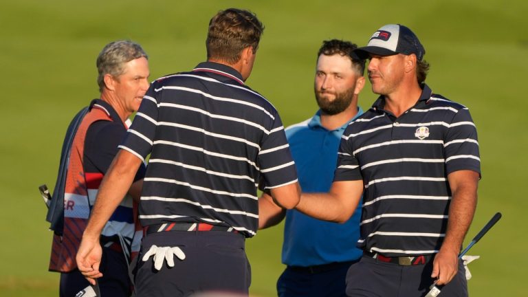 United States' Scottie Scheffler, left shakes hands with United States' Brooks Koepka, right and Europe's Jon Rahm on the 18th green after their match was tied in their afternoon Fourballs match at the Ryder Cup golf tournament at the Marco Simone Golf Club in Guidonia Montecelio, Italy, Friday, Sept. 29, 2023. (Gregorio Borgia/AP)