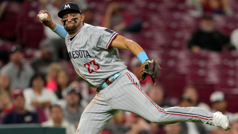 Minnesota Twins third baseman Royce Lewis (23) attempts to throw out Cincinnati Reds' Nick Senzel (not shown) at first base in the seventh inning of a baseball game in Cincinnati, Monday, Sept. 18, 2023. Senzel was safe on the play. (Jeff Dean/AP)