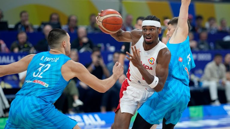 Canada's Shai Gilgeous-Alexander, centre, drives past Slovenia's Bine Prepelic (32) and Aleksej Nikolic, right, during the first half of a Basketball World Cup quarterfinal game in Manila, Philippines, Wednesday, Sept. 6, 2023. (Aaron Favila/AP Photo)