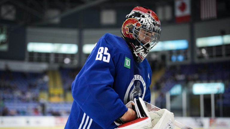 Vancouver Canucks goalie Ty Young puts his blocker back on after taking a break during the opening day of the NHL hockey team's training camp, in Victoria, Thursday, Sept. 21, 2023. (Darryl Dyck/THE CANADIAN PRESS)