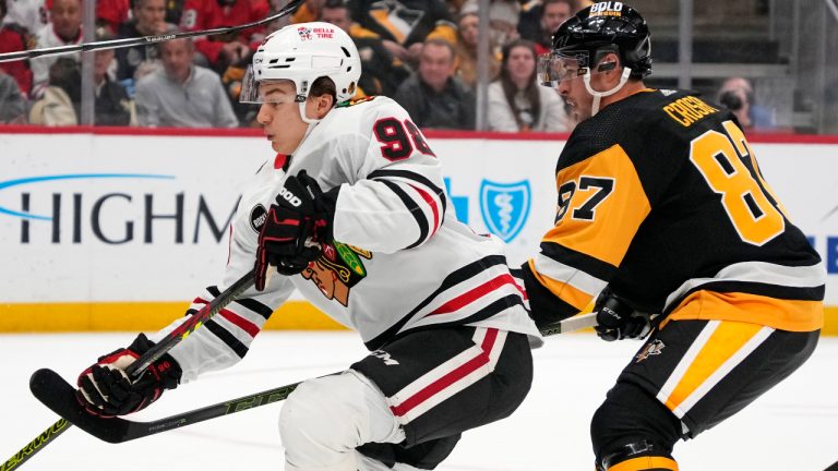 Chicago Blackhawks' Connor Bedard, left, tries to get his stick on the puck with Pittsburgh Penguins' Sidney Crosby (87) defending during the first period of a NHL hockey game in Pittsburgh, Tuesday, Oct. 10, 2023. (Gene J. Puskar/AP)