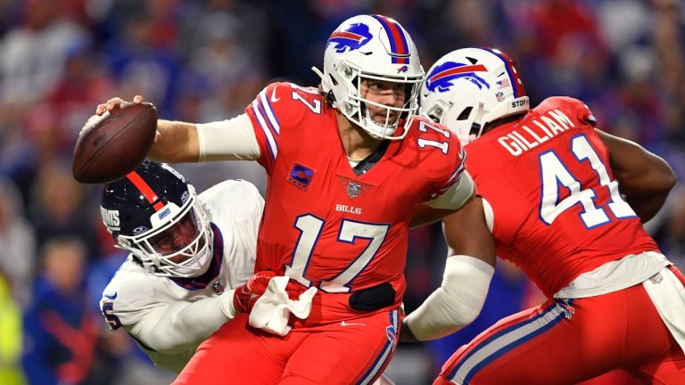 Buffalo Bills quarterback Josh Allen (17) tries to break free from New York Giants linebacker Kayvon Thibodeaux, left, during the second half of an NFL football game. (Adrian Kraus/AP)