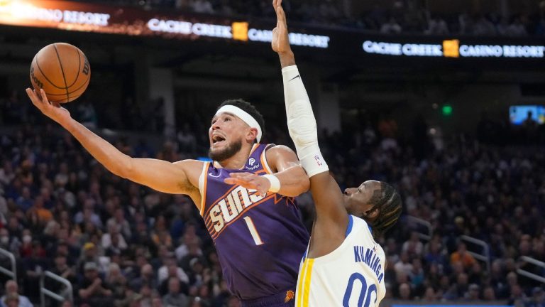 Phoenix Suns guard Devin Booker is fouled by Golden State Warriors forward Jonathan Kuminga during the first half of an NBA basketball game in San Francisco, Tuesday, Oct. 24, 2023. (Jeff Chiu/AP Photo)