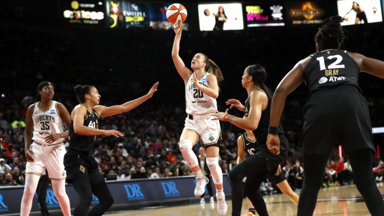 New York Liberty guard Sabrina Ionescu (20) drives to the basket between Las Vegas Aces center Kiah Stokes, left, and forward Candace Parker (3) during the first half of a WNBA basketball game Thursday, June 29, 2023, in Las Vegas. (Steve Marcus/Las Vegas Sun via AP)