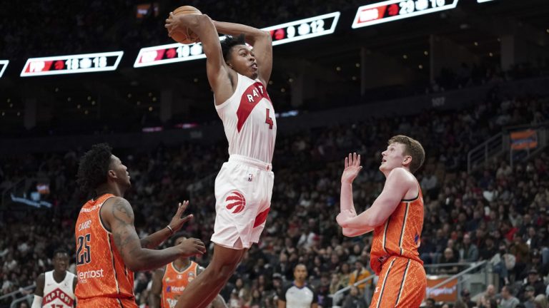 Toronto Raptors forward Scottie Barnes (4) dunks the ball as Cairns Taipans guard Elfred Peyton (25) and guard Sam Waardenburg (21) look on during first half exhibition basketball action in Toronto, Sunday, Oct. 15, 2023. (Arlyn McAdorey/CP)