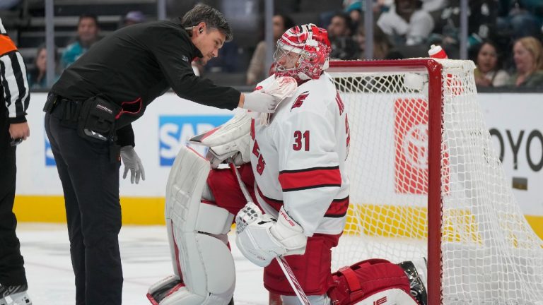 Carolina Hurricanes goaltender Frederik Andersen (31) is checked on by a trainer during the first period of an NHL hockey game against the San Jose Sharks in San Jose, Calif., Tuesday, Oct. 17, 2023. (Jeff Chiu/AP)