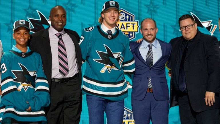 Quentin Musty, centre, poses with San Jose Sharks officials after being picked by the team during the first round of the NHL hockey draft Wednesday, June 28, 2023, in Nashville, Tenn. (George Walker IV/AP)