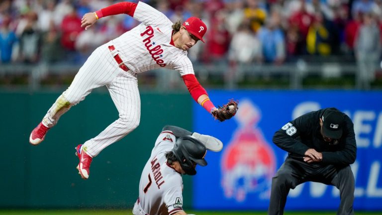 Arizona Diamondbacks' Corbin Carroll steals second under Philadelphia Phillies second baseman Bryson Stott during the fifth inning in Game 7 of the baseball NL Championship Series in Philadelphia Tuesday, Oct. 24, 2023. (Matt Slocum/AP)