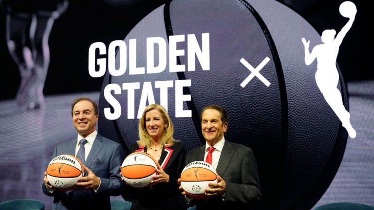 Golden State Warriors CEO Joe Lacob, WNBA Commissioner Cathy Engelbert and Warriors Co-Executive Chairman Peter Guber pose for pictures after an WNBA expansion franchise for the San Francisco Bay Area was announced at Chase Center in San Francisco, Thursday, Oct. 5, 2023. (Eric Risberg/AP Photo)