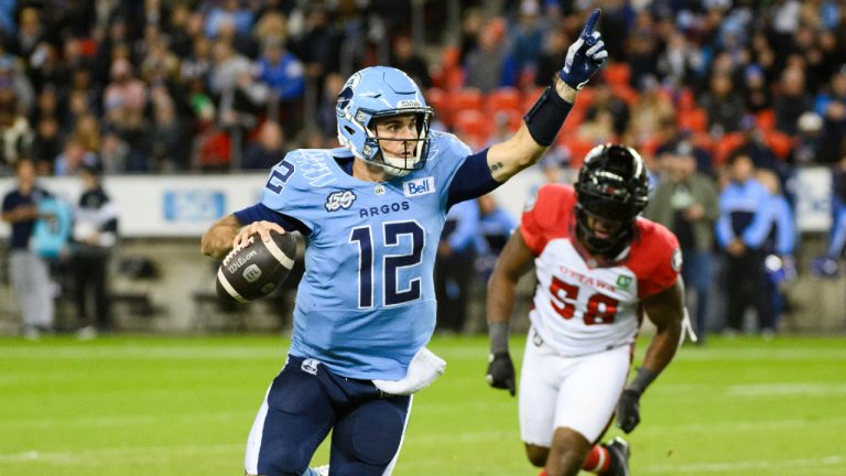 Toronto Argonauts quarterback Chad Kelly (12) runs the ball under pressure by Ottawa Redblacks defensive lineman Bryce Carter (58) during first half CFL action against the Ottawa Redblacks, in Toronto, Saturday, Oct. 14, 2023. (Christopher Katsarov/CP)